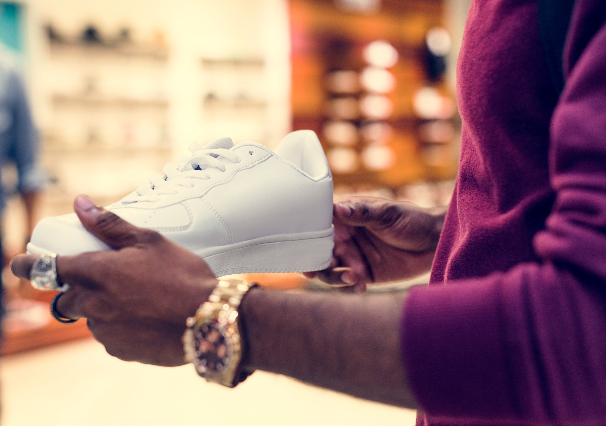 African man holding a white sneakers